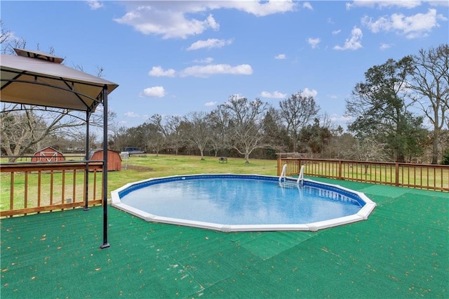 view of swimming pool with a gazebo, a wooden deck, and a lawn