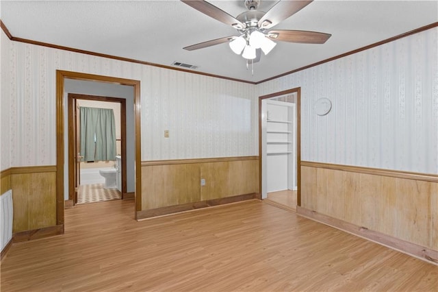 unfurnished room featuring crown molding, ceiling fan, and light hardwood / wood-style floors