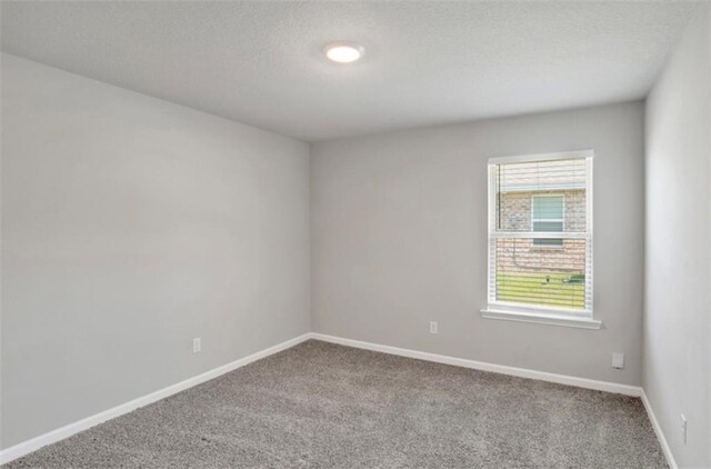 carpeted spare room with baseboards and a textured ceiling