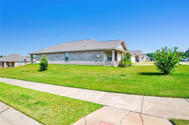 view of front facade with a front yard and brick siding