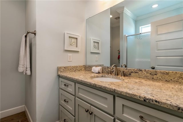 full bathroom with crown molding, a stall shower, vanity, wood finished floors, and baseboards