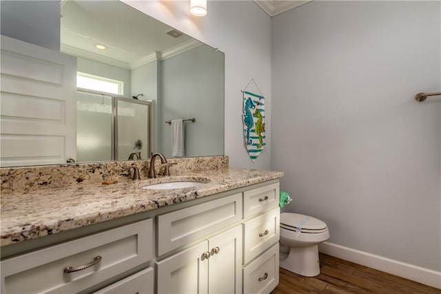 bathroom featuring crown molding, a stall shower, vanity, wood finished floors, and baseboards