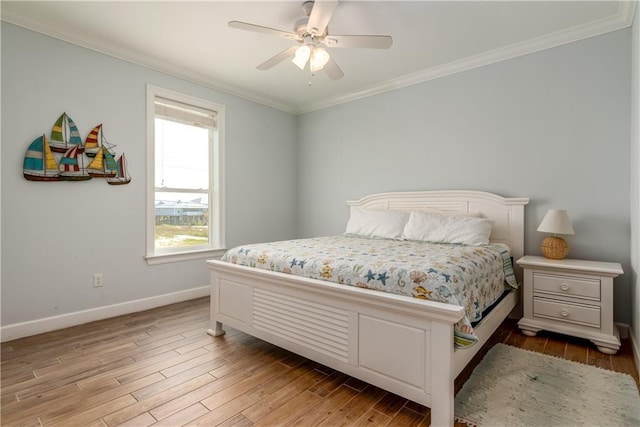 bedroom with ornamental molding, light wood-type flooring, baseboards, and a ceiling fan