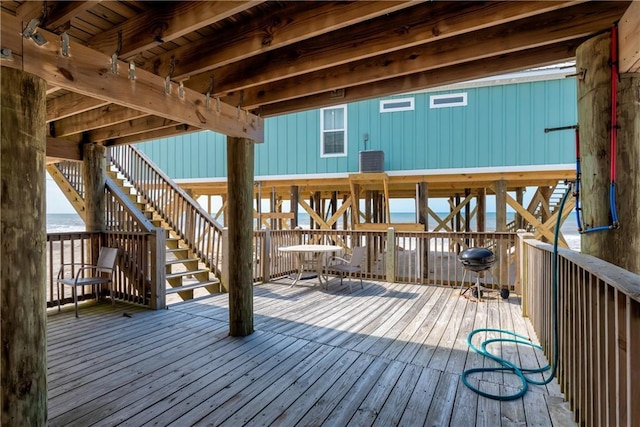 deck with stairway and a water view