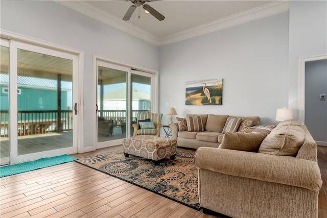 living room with ceiling fan, ornamental molding, and wood finished floors