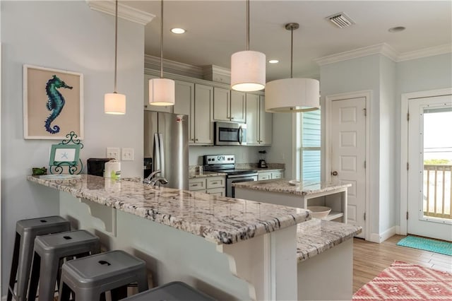 kitchen featuring stainless steel appliances, a peninsula, visible vents, hanging light fixtures, and crown molding