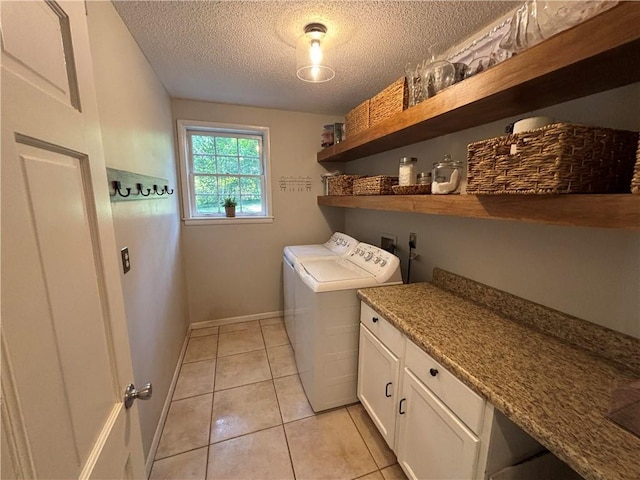 5911 Shenandoah Rd N, Mobile, AL 36608 - laundry area with washer and dryer, a textured ceiling, cabinet space, and light tile patterned flooring
