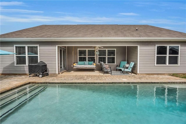 rear view of house with a shingled roof, an outdoor hangout area, a patio area, ceiling fan, and an outdoor pool