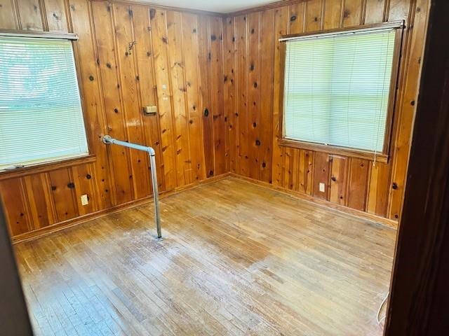 empty room featuring wooden walls and wood finished floors