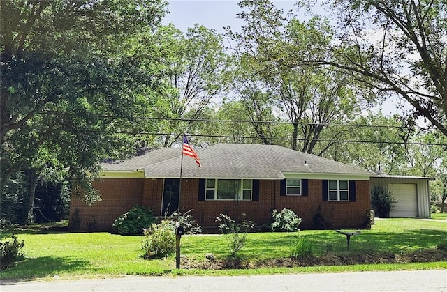 single story home with an attached garage, a front lawn, and brick siding