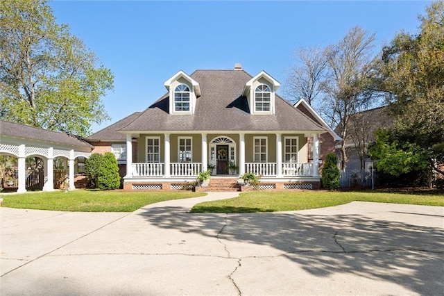 cape cod-style house featuring a porch, fence, and a front lawn