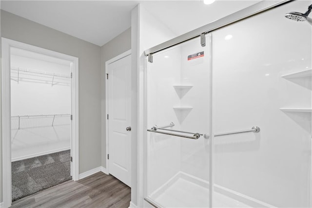 bathroom with an enclosed shower and wood-type flooring