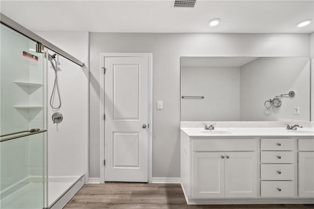 bathroom featuring hardwood / wood-style floors, vanity, and an enclosed shower