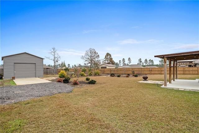 view of yard featuring a patio area, a garage, and an outdoor structure