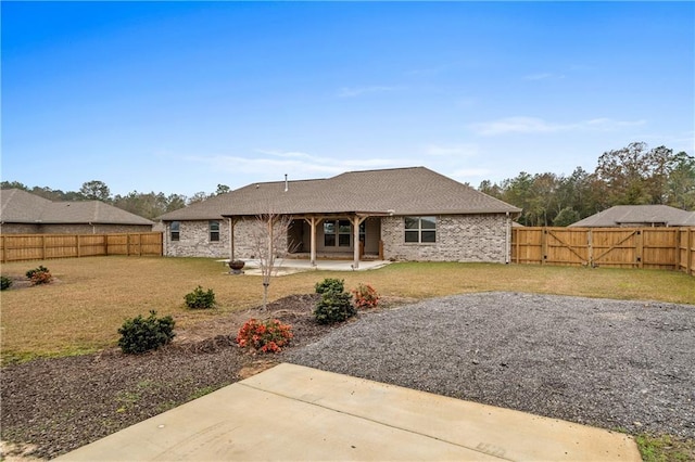 rear view of property featuring a yard and a patio