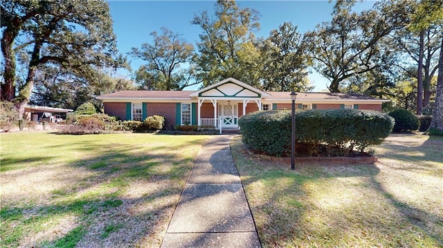 single story home with a front yard, covered porch, and brick siding