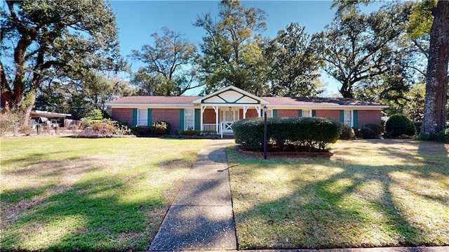 ranch-style house featuring covered porch and a front yard