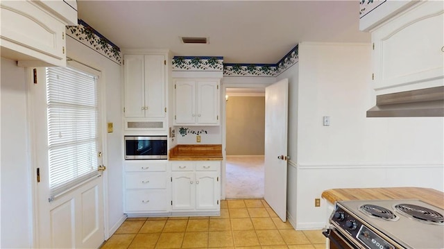 kitchen featuring under cabinet range hood, stainless steel appliances, visible vents, white cabinetry, and light countertops