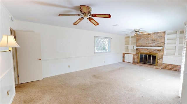 unfurnished living room featuring a brick fireplace, carpet, built in shelves, and ceiling fan