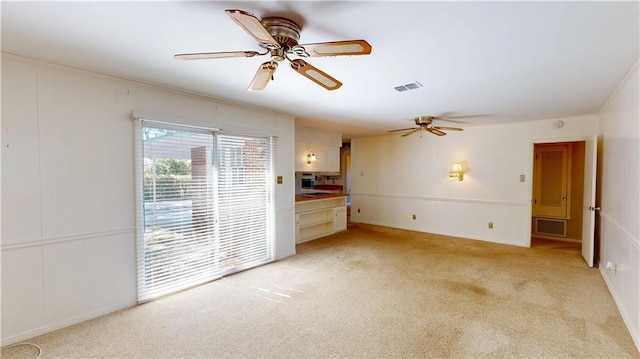 spare room featuring light carpet, visible vents, and a ceiling fan