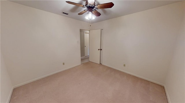 empty room featuring light carpet, baseboards, and visible vents