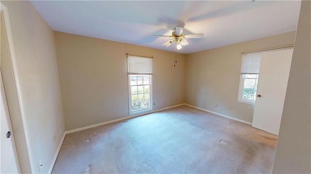 unfurnished room with carpet floors, baseboards, and a ceiling fan