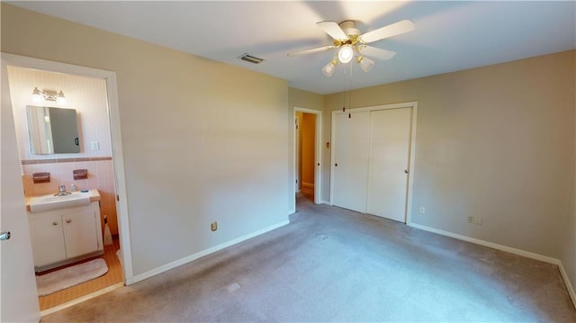 unfurnished bedroom with a closet, visible vents, a sink, and baseboards