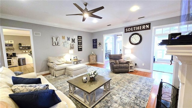 living room featuring visible vents, plenty of natural light, and crown molding