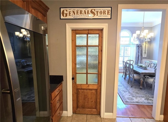 doorway to outside with an inviting chandelier and crown molding