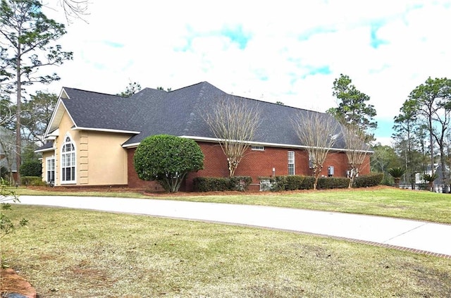 view of front of home featuring stucco siding and a front yard