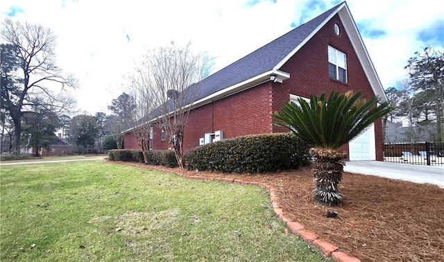 view of home's exterior featuring brick siding, driveway, and a yard