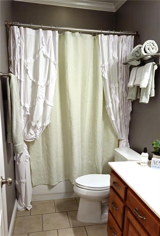 full bath with crown molding, toilet, tile patterned floors, shower / bath combination with curtain, and vanity