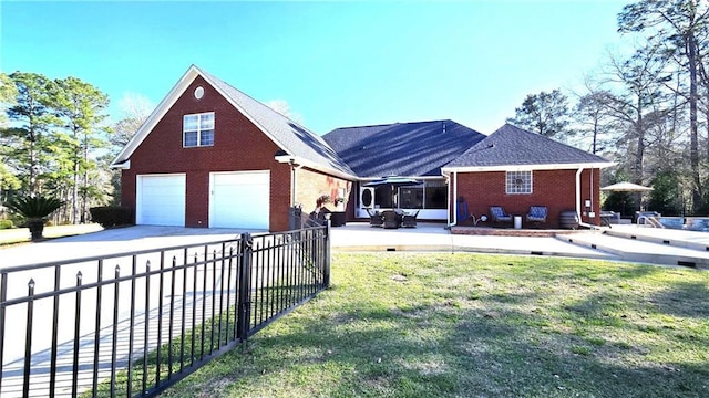 view of front of house featuring brick siding, driveway, a patio, and fence