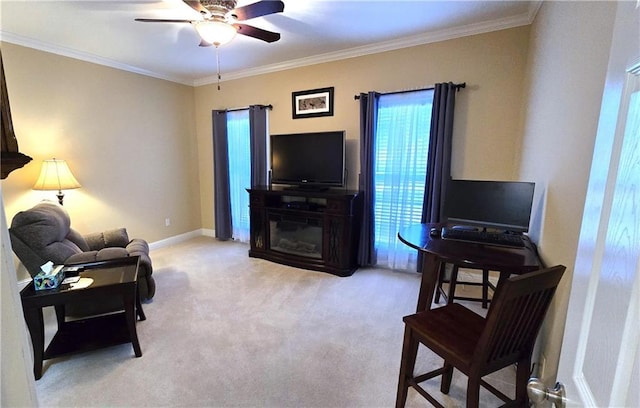 carpeted living area with a glass covered fireplace, crown molding, a ceiling fan, and baseboards