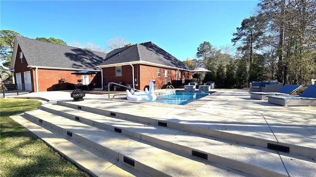 view of swimming pool featuring a water slide, a patio, and fence