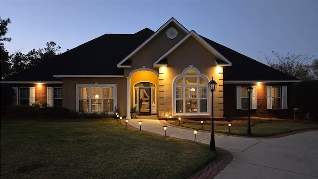 view of front of home with a front yard and stucco siding