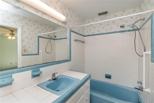 bathroom featuring a ceiling fan, shower / bath combination, vanity, and wallpapered walls