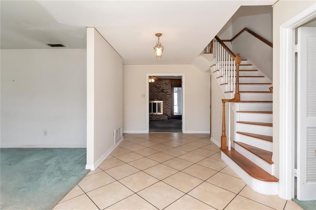 entrance foyer featuring visible vents, a fireplace, and light tile patterned floors