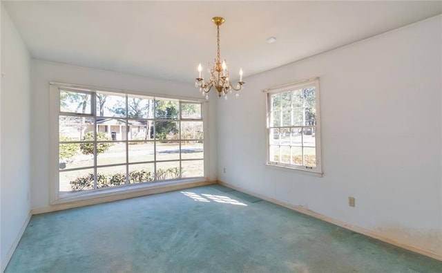 carpeted spare room with baseboards and a notable chandelier