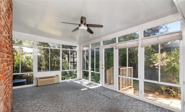 unfurnished sunroom featuring a wall unit AC and ceiling fan