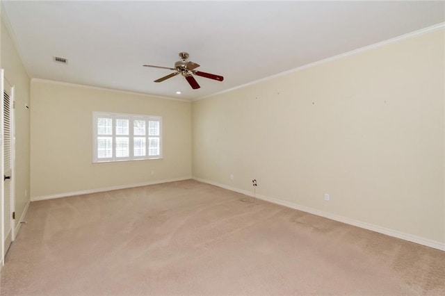 empty room with crown molding, light carpet, and ceiling fan