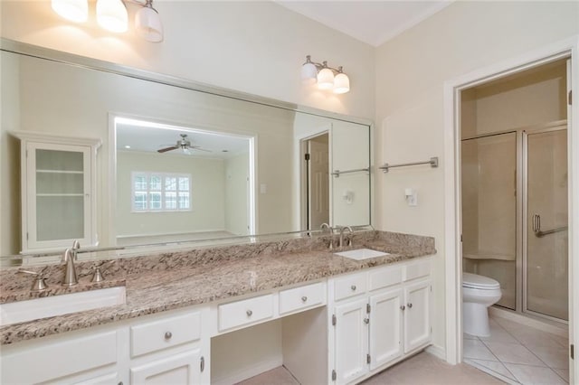 bathroom featuring vanity, tile patterned flooring, ceiling fan, toilet, and an enclosed shower