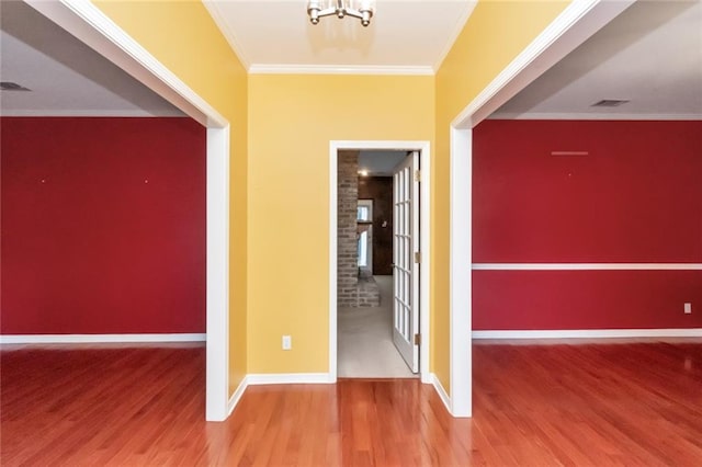 entryway featuring wood-type flooring, crown molding, and brick wall