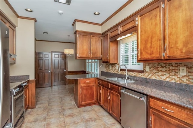 kitchen with sink, kitchen peninsula, hanging light fixtures, appliances with stainless steel finishes, and crown molding