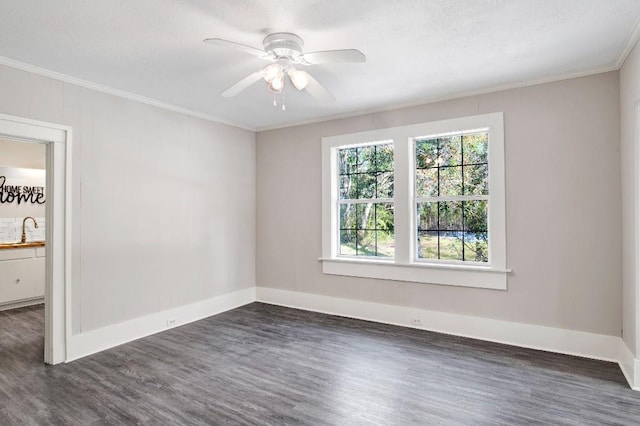 spare room with dark hardwood / wood-style floors, ornamental molding, sink, and ceiling fan