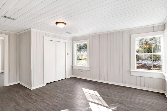 unfurnished bedroom with dark hardwood / wood-style floors, wooden ceiling, and a closet