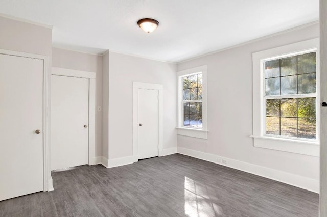 unfurnished bedroom featuring dark hardwood / wood-style flooring and crown molding