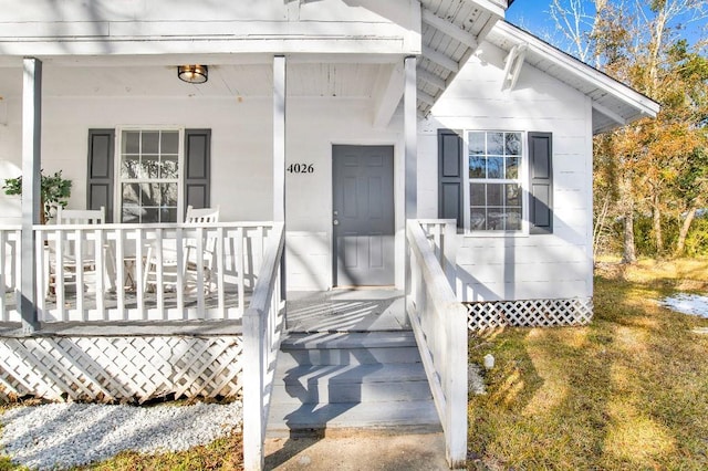 view of exterior entry featuring covered porch