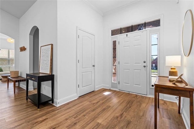 entrance foyer with crown molding and wood-type flooring