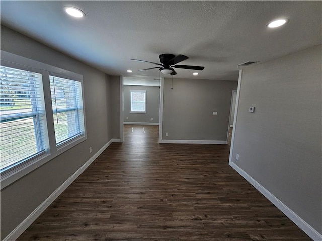 spare room featuring dark hardwood / wood-style flooring, a textured ceiling, and ceiling fan